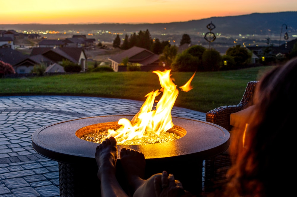 A Woman Relaxes By A Roaring Firepit