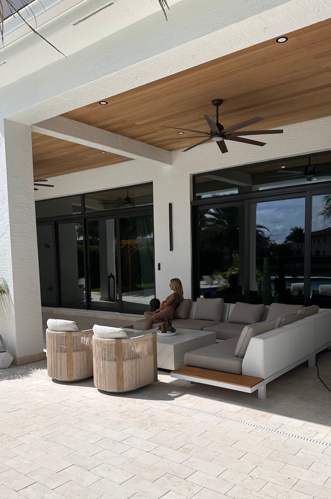 Seating zones—sectional and swivels—arranged beneath the Ayous ceiling for effortless entertaining